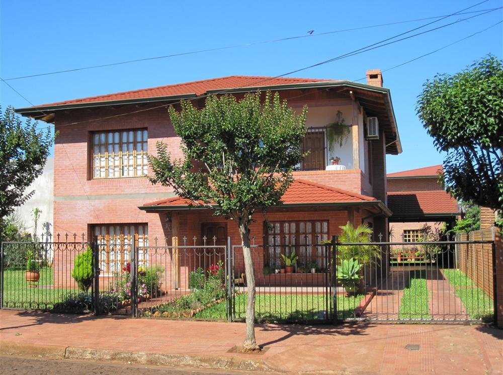 Vivienda de dos plantas en ladrillo con techo de tejas de acero gravilladas terracota en Oberá, Misiones